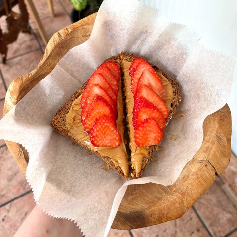 Multigrain toast with peanut butter, strawberries, and honey